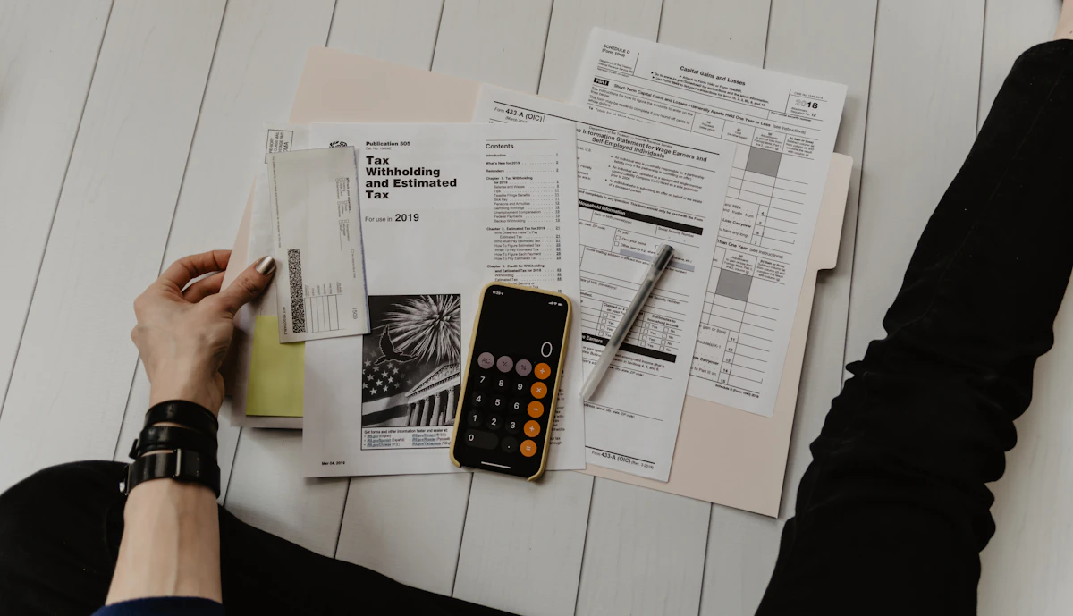 Calculator next to tax forms on a quiet home desk