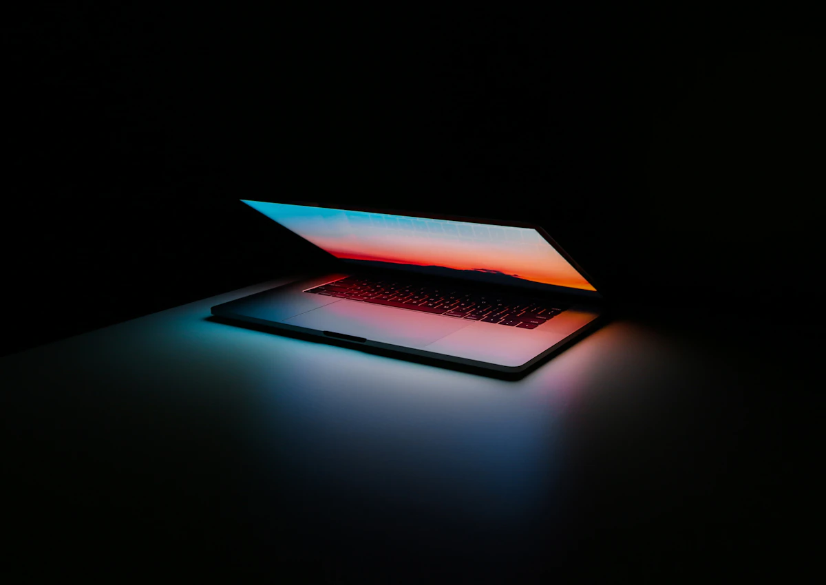 A laptop closing up on a home desk in the evening light